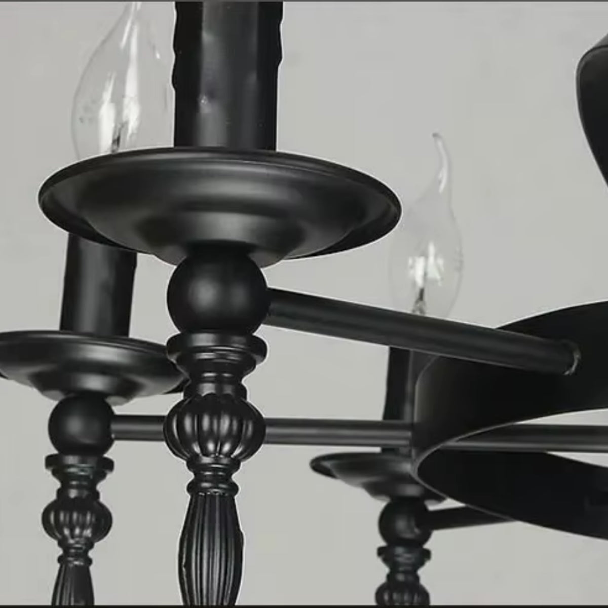 Close-up of black metal candelabra arms with decorative finials and candle sockets