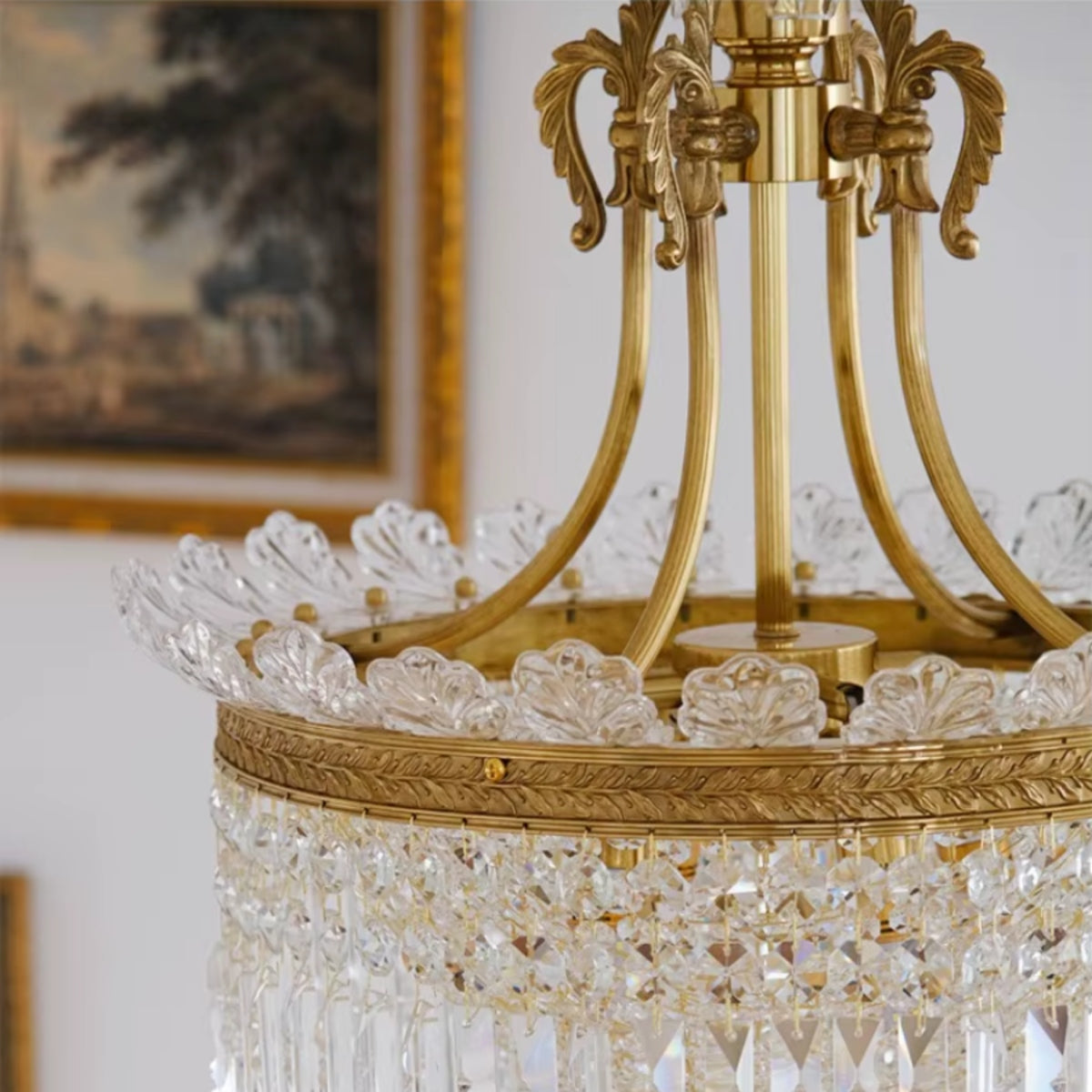 Gold canopy and curved arms above a clear crystal prism drum pendant light