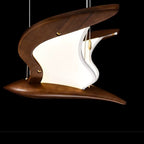 Close-up wooden bird-style pendant light with LED glow, curved wing shade and warm wood