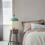 Shallow pendant light with teal metal shade and gold chain cord
