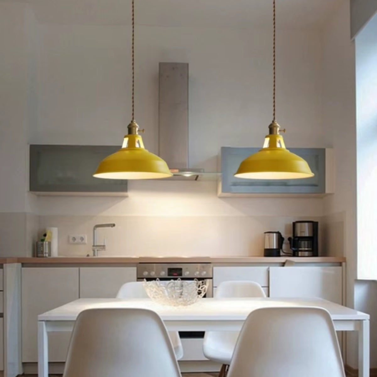 Pair of shallow pendant lights with yellow metal shades and gold chain cords