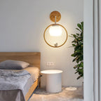 Wood halo bird wall light with warm lit globe and bird figure centered in ring