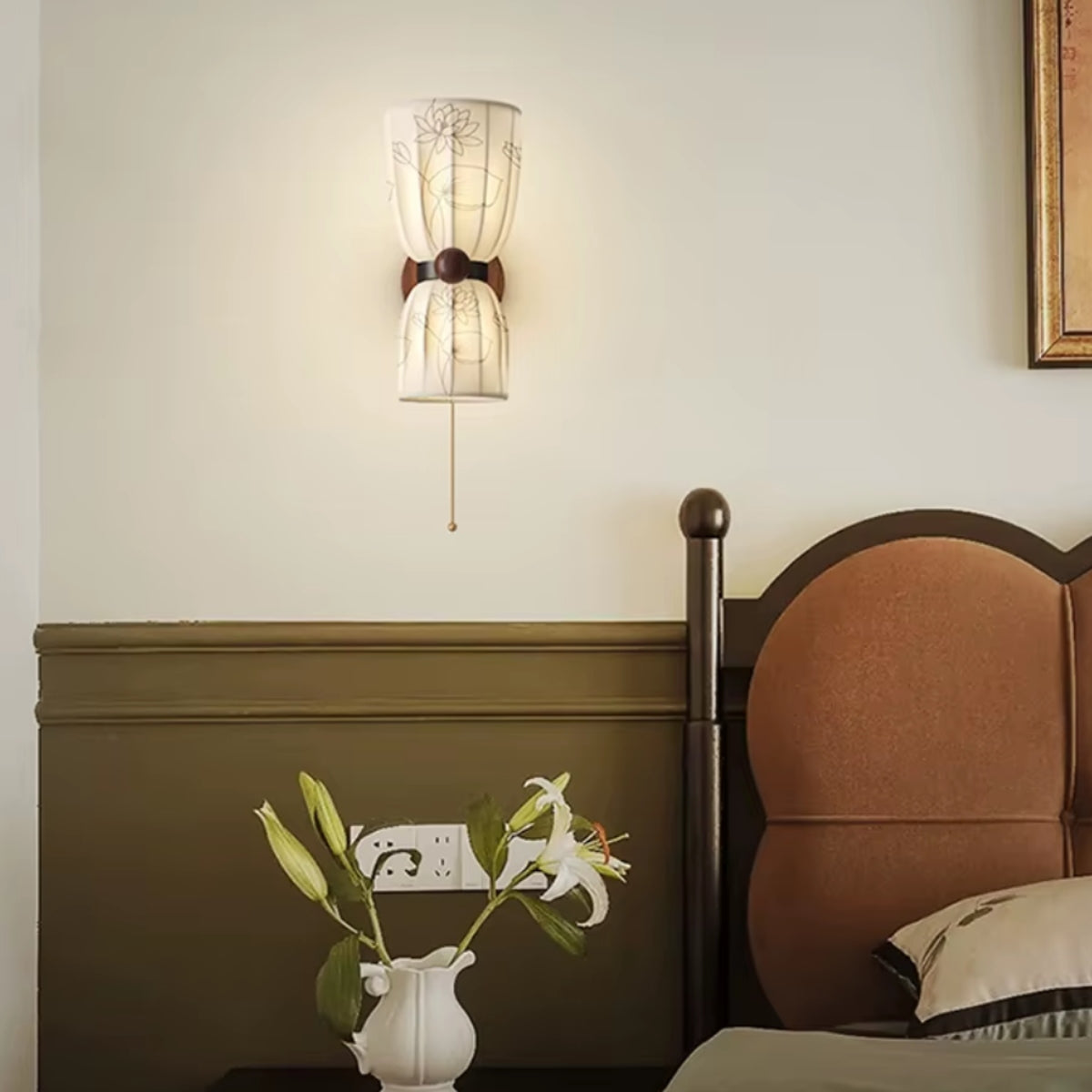 Dual cone wall light with white shades, dark round backing, and brass cord