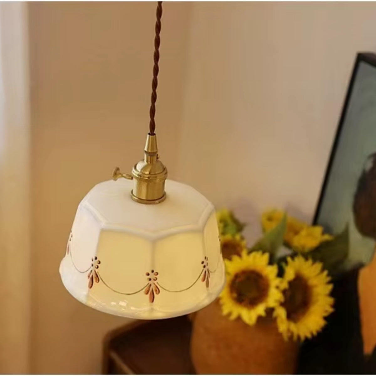Pendant light with white tapered drum shade and floral embroidery, brass base