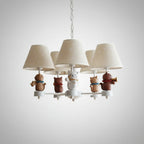 White conical chandelier with three fabric shades and cat figurines on chain