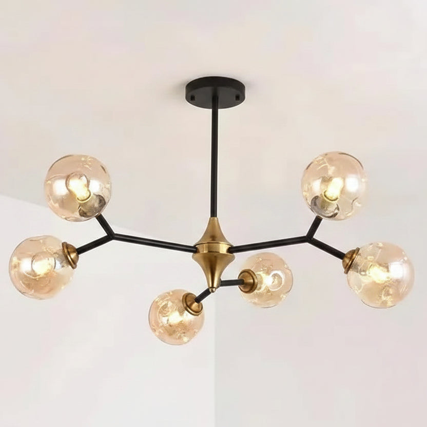 Minimalist bubble chandelier with five lit glass globes, black stems, and gold central cap