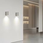 D-shaped wall light pair with cylindrical shades, casting warm light on wall
