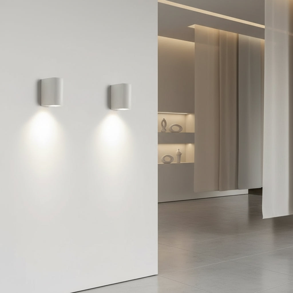 D-shaped wall light pair with cylindrical shades, casting warm light on wall
