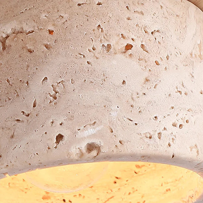 Travertine stone pendant shade with speckled texture and warm inner glow