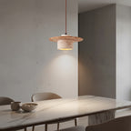 Layered pendant light with travertine-toned shade and warm glowing interior