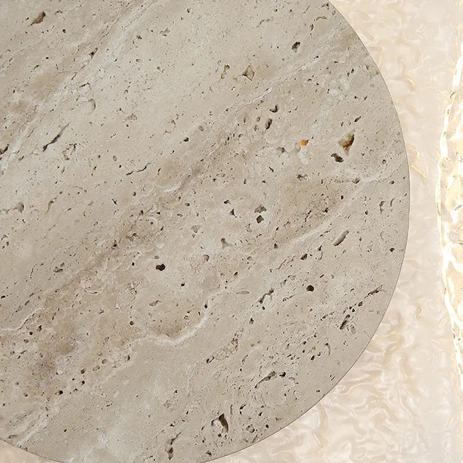 Round travertine backlit wall sconce close-up: textured tan outer ring and grey disc