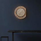 Round travertine backlit wall sconce with textured outer ring and grey inner disc