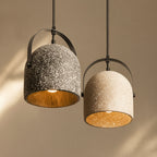 Speckled bell pendant lights with dark and white shades; black frames and gold interior.