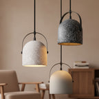 Speckled bell pendant lights with gray and white shades, black frames and gold inside.