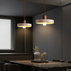 Kivor round travertine pendant light trio with warm bulbs and wood mounts