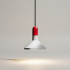 Conical pendant light with red cap, white metal shade, and soft warm light