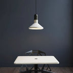 Conical pendant light with black cord, white inner shade, and warm glow