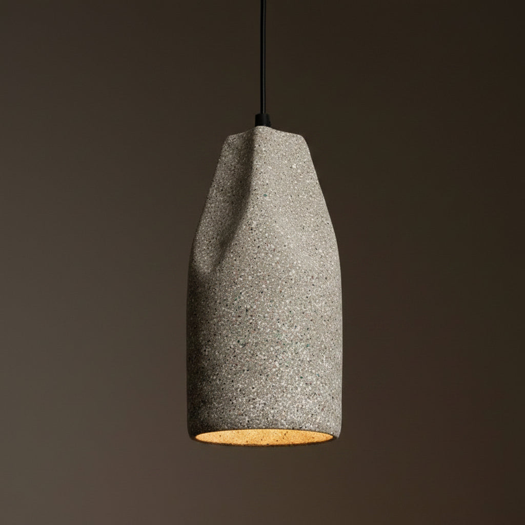 Speckled white concrete cylinder pendant light with warm amber underside
