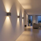 Concrete cube wall lights with square shades, warm light on a hallway wall