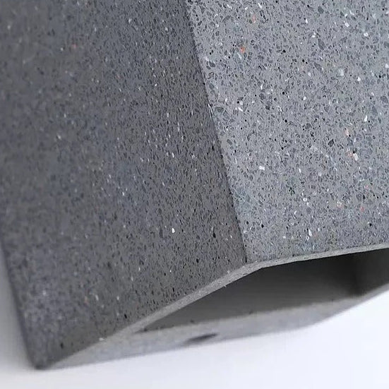 Concrete cube wall light close-up, speckled concrete texture and corner edge