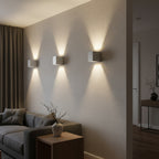 Concrete cube wall light fixtures with square shades, warm illumination on wall