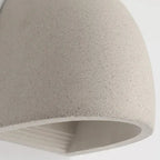 Half-dome wall light close-up of gray textured shade with warm light opening
