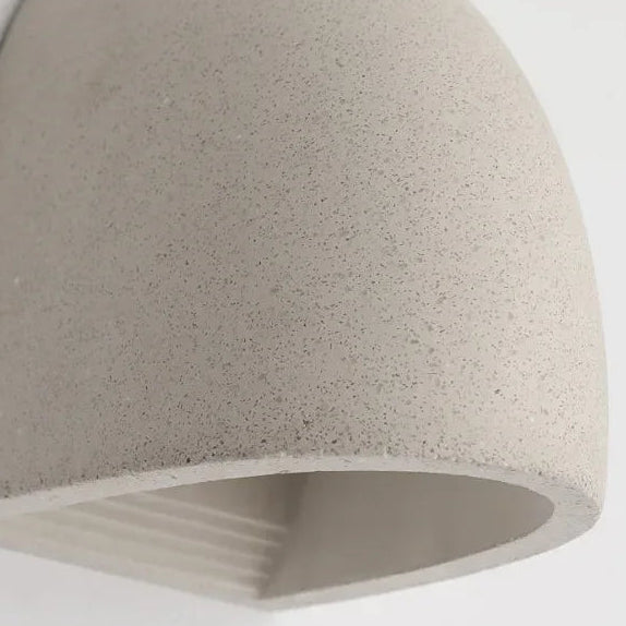 Half-dome wall light close-up of gray textured shade with warm light opening